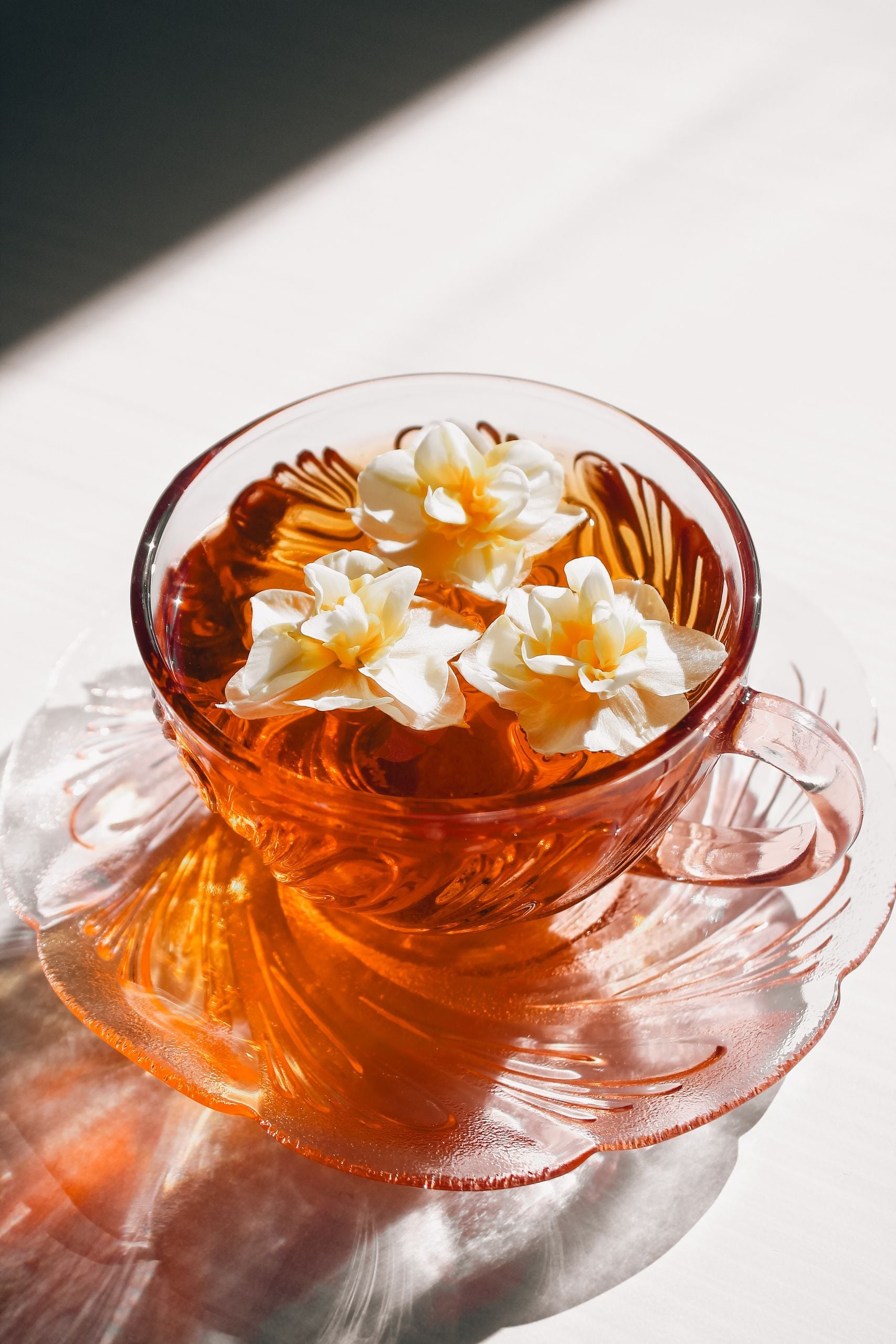 A beautifully crafted transparent tea cup adorned with floating daffodils, embracing a vintage aesthetic.